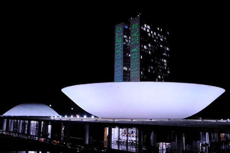 As torres do Palácio do Congresso Nacional iluminadas com projeção com dizeres 